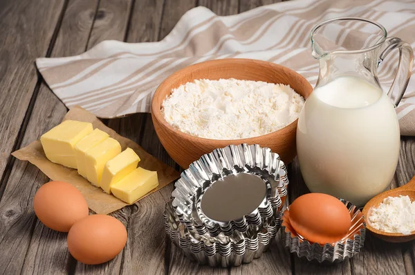 Ingredientes para hornear: leche, mantequilla, huevos y harina. Fondo rústico . — Foto de Stock