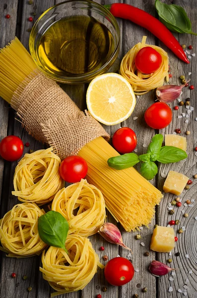Pasta, vegetables, herbs and spices for Italian food on the rustic wooden table. — Stock Photo, Image