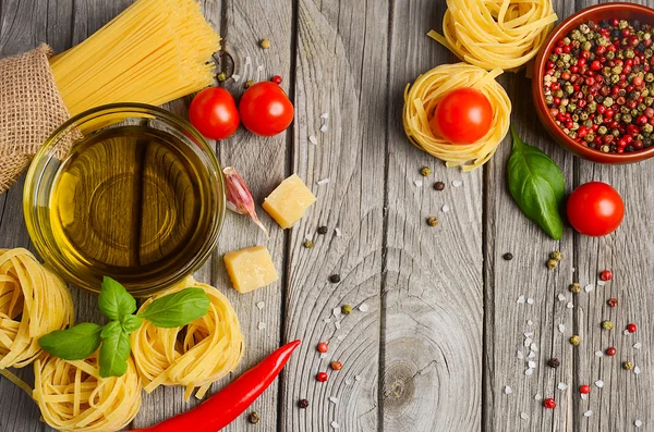 Tészta, zöldségekből, gyógynövényekből és fűszerek olasz ételeket a rusztikus fa tábla. — Stock Fotó
