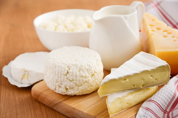 Taze süt ve süt ürünleri. Süt, peynir, brie, camembert ve süzme peynir ahşap arka plan üzerinde. — Stok fotoğraf