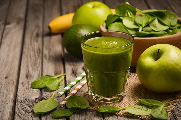 Frullato verde con mela, banana, avocado e spinaci su fondo rustico in legno . — Foto Stock