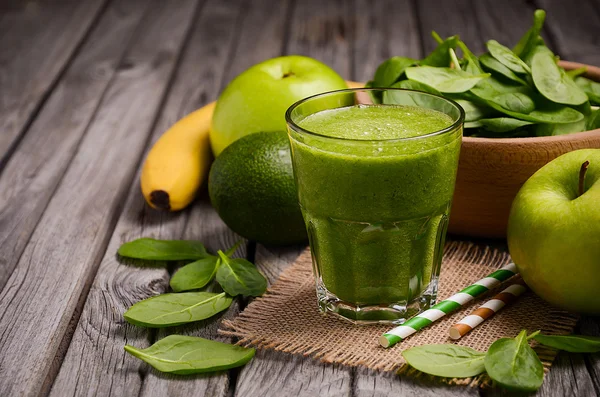 Batido verde con manzana, plátano, aguacate y espinacas sobre un fondo rústico de madera . — Foto de Stock