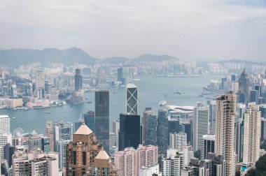 Hong Kong, Çin. 17 Aralık 2016. Kentsel ufuk çizgisi ve kowloon körfezi görüntüsü Hong Kong 'daki Victoria Tepesi' nin tepesinden puslu bir gökyüzünün altında..