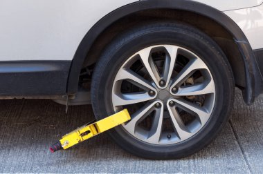 Yasadışı park etmiş bir aracın lastiğine kenetlenmiş bir tekerlek kelepçesi..