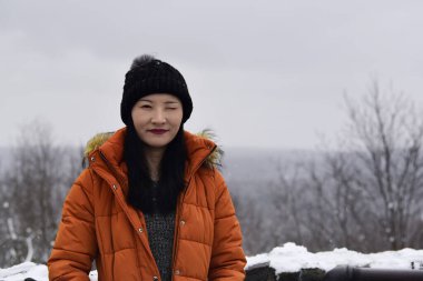 Yeni İngiltere kış gününde Çinli bir kadın kameraya göz kırpıyor..