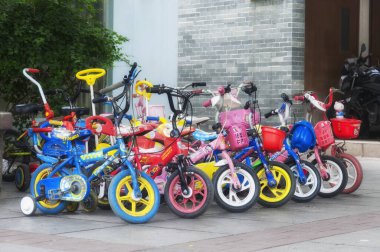 Macau, China. December 19, 2016. Colorful childrens bicycles parked on a sideway in the city of Macau China.