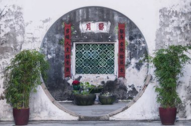 Macau, Çin. 19 Aralık 2016. Geleneksel Çin ay kapısı ve avlu penceresi kaligrafi sancakları ve bambu bitkileriyle, Macau, Çin.