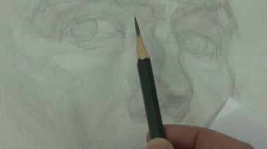 Bir kağıt parçası ile resmin bir kısmını kaplayan grafit kalem ile genç modelin burnunun çizim