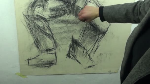 Drawing a fast sketch of a man's legs with a charcoal stick — 图库视频影像