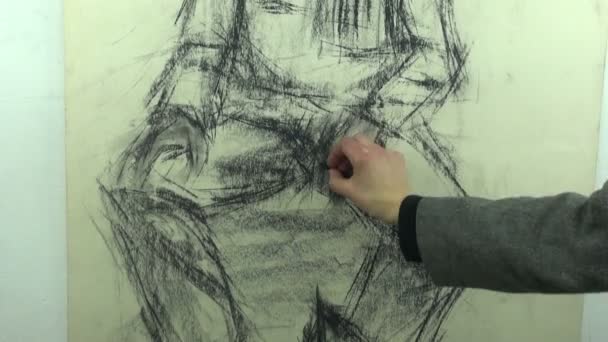 Drawing a fast sketch of a man with a cap and a shawl with a black charcoal stick — Stock video