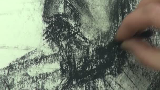 Drawing a fast sketch of a middle aged man's head with a cap with a charcoal stick — Stockvideo