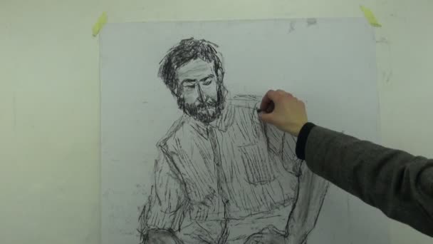 Drawing a fast sketch of a sitting man with a charcoal stick — 图库视频影像