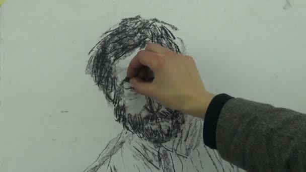 Drawing a fast sketch of a sitting man's head with a charcoal stick — Stock Video