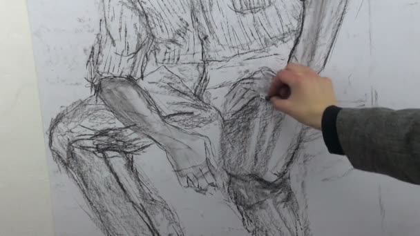 Drawing a fast sketch of a sitting man's and hand with a charcoal stick — Αρχείο Βίντεο