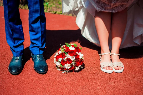 Τα πόδια του ο γαμπρός και η νύφη με μια γαμήλια ανθοδέσμη — Φωτογραφία Αρχείου