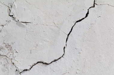 Çatlamak. Doku eski beyaz sıva boyalı. Kırık duvar.