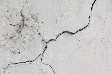 Çatlamak. Doku eski beyaz sıva boyalı. Kırık duvar.