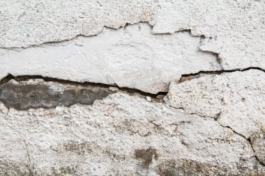 Çatlamak. Doku eski beyaz sıva boyalı. Kırık duvar.