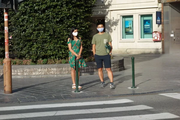 ブリュッセル ベルギー 2020年8月4日 歩行者交差点の前の歩道で待っている保護外科マスクを持つ歩行者のカップル — ストック写真