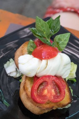 Domates, mozzarella ve fesleğen bruschetta, İtalyan tarifi. Seçici odak
