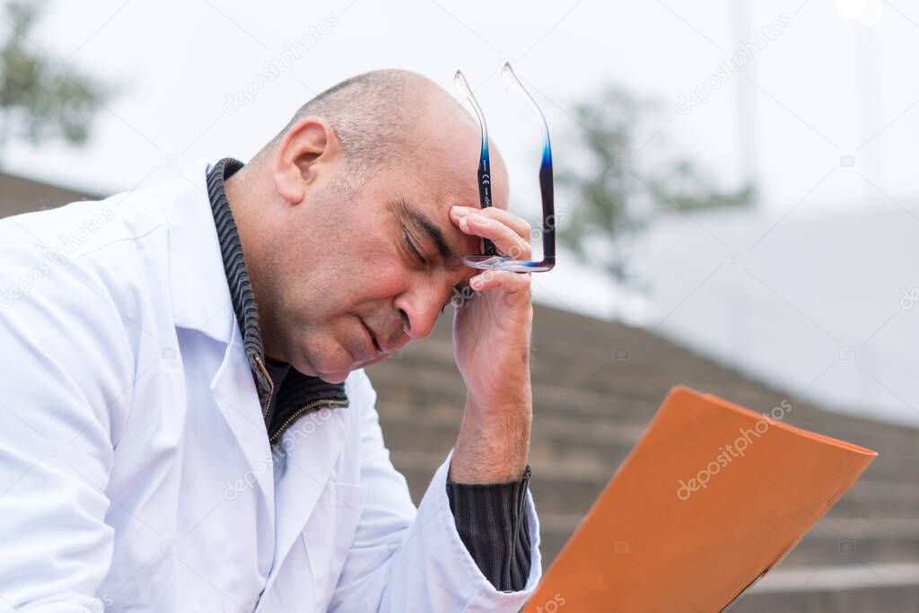 Work problem. Desperate, tired, disappointed medical worker facepalming reading bad news on paperworks