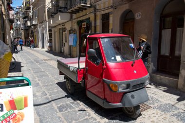 Cefal, İtalya - 8 Mayıs 2019: Kırmızı Piaggio Ape, Piaggio tarafından üretilen ve pazarlanan üç tekerlekli hafif ticari bir araç.