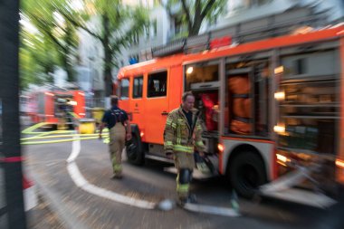 Berlin, Almanya - 6 Ağustos 2020: İtfaiyeci ve itfaiye aracı, açık hava. Etkin büyüt