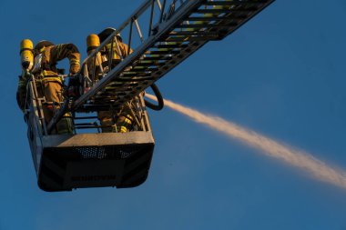 Berlin, Almanya - 6 Ağustos 2020: İtfaiyeciler yangına karşı merdiven tırmanıp yangını söndürüyorlar
