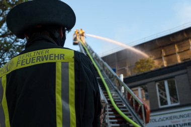 Berlin, Almanya - 6 Ağustos 2020: İtfaiyeciler yangına karşı merdiven tırmanıp yangını söndürüyorlar