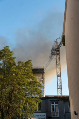 Berlin, Almanya - 6 Ağustos 2020: Bir inşaat sahasının yakınındaki yangından kaynaklanan hasar ve duman