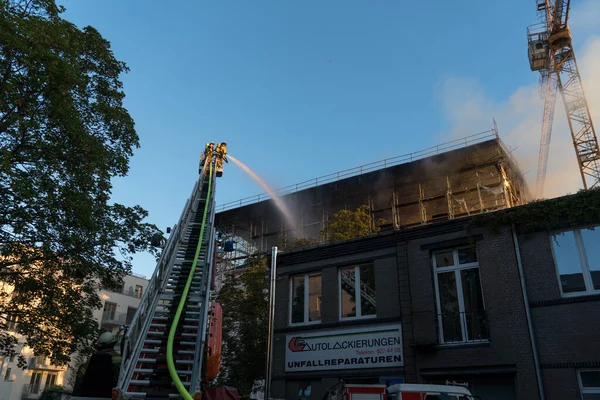 Berlin, Almanya - 6 Ağustos 2020: İtfaiyeciler yangına karşı merdiven tırmanıp yangını söndürüyorlar