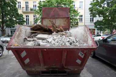 Berlin, Almanya - 4 Haziran 2021: Çakıl taşı veya kayalar, bir konteynırda inşaat ve kahverengi toprak yığınları
