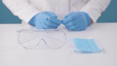 Klinikteki bir hemşire ameliyattan önce gözlük ve yüz maskesi takar..