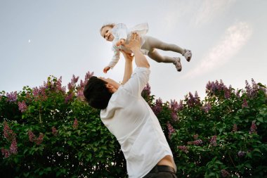 Baba ve kızı yazın parkta yürüyorlar..