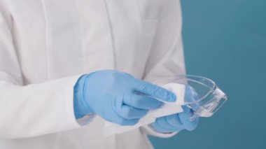Doktor dezenfeksiyon için antiseptikle güvenlik bardaklarını temizler..