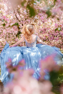 Kadın elbise içinde elma bahçesinde koşuyor..