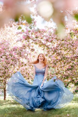 Gülümseyen kız gül bahçesinin arka planında dans ediyor..