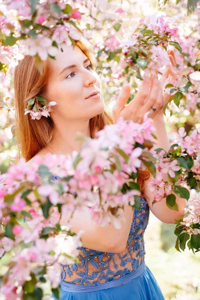 一个小女孩呼吸着一棵开花的苹果树的芬芳. — 图库照片