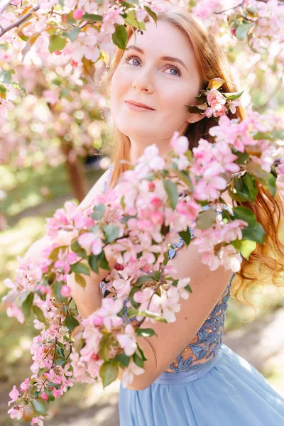 女孩在花园里吸入樱花的芬芳. — 图库照片
