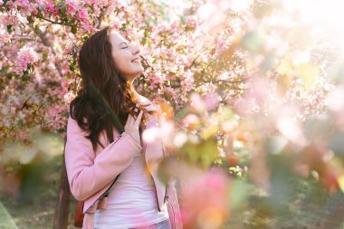 Genç bir kadın rüyasında çiçek açmış bir elma bahçesinde duruyor..