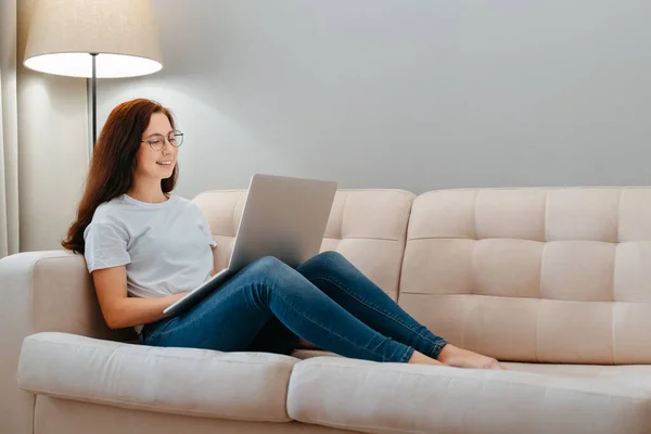 Young happy woman works on a laptop.