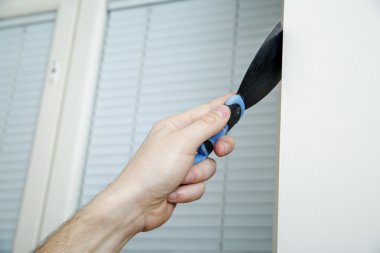 Erkek duvar köşe yakınındaki duvara Macun bıçağı tutan.