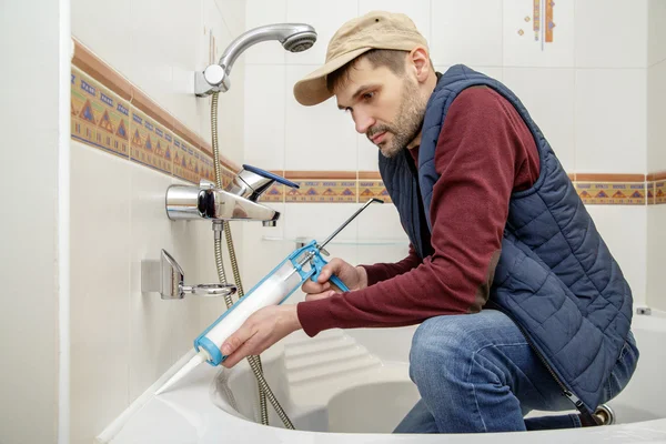 Hombre aplicando sellador de silicona . — Foto de Stock