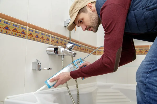 Hombre aplicando sellador de silicona . — Foto de Stock