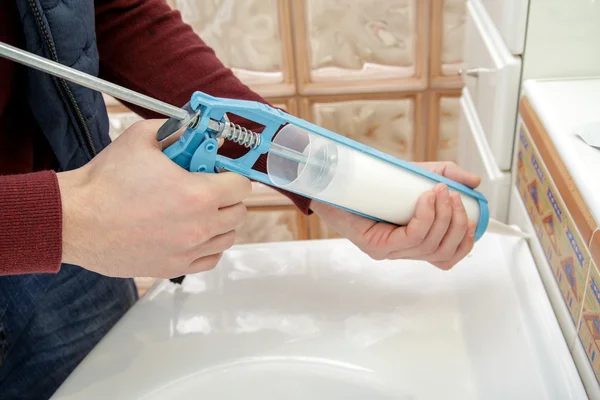 Manos de trabajador aplicando sellador de silicona . — Foto de Stock