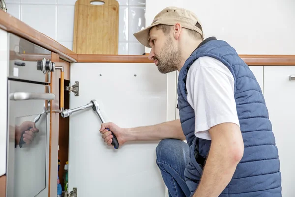 Worker repairing the sink in the kitchen. — Stock Photo, Image