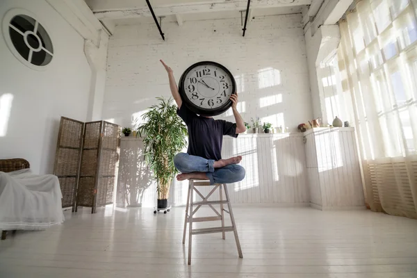 Hombre del reloj. Un hombre sentado en una silla con un gran reloj . —  Fotos de Stock