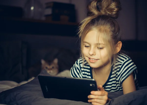 Gyönyörű szőke lány, és mosolyogva néz tabletta — Stock Fotó