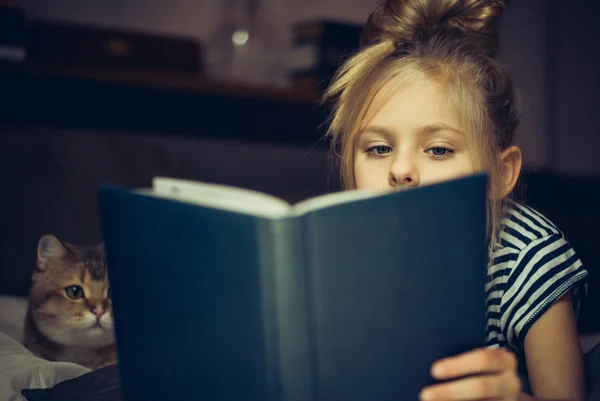 Junges Mädchen liest einer Katze Buch vor — Stockfoto