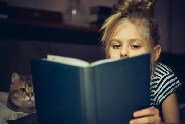 La ragazza legge il libro a un gatto — Foto Stock